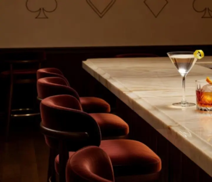 Koktajl bar w kremowym wnętrzu restauracji, z kolorowymi koktajlami w świetle świec